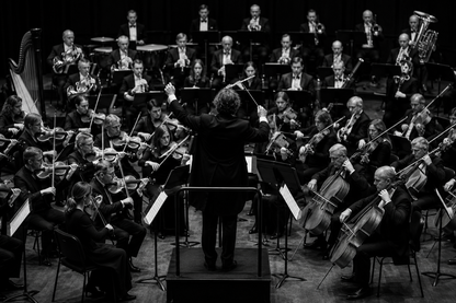 A black and white image with an orchestra set up around a conductor.